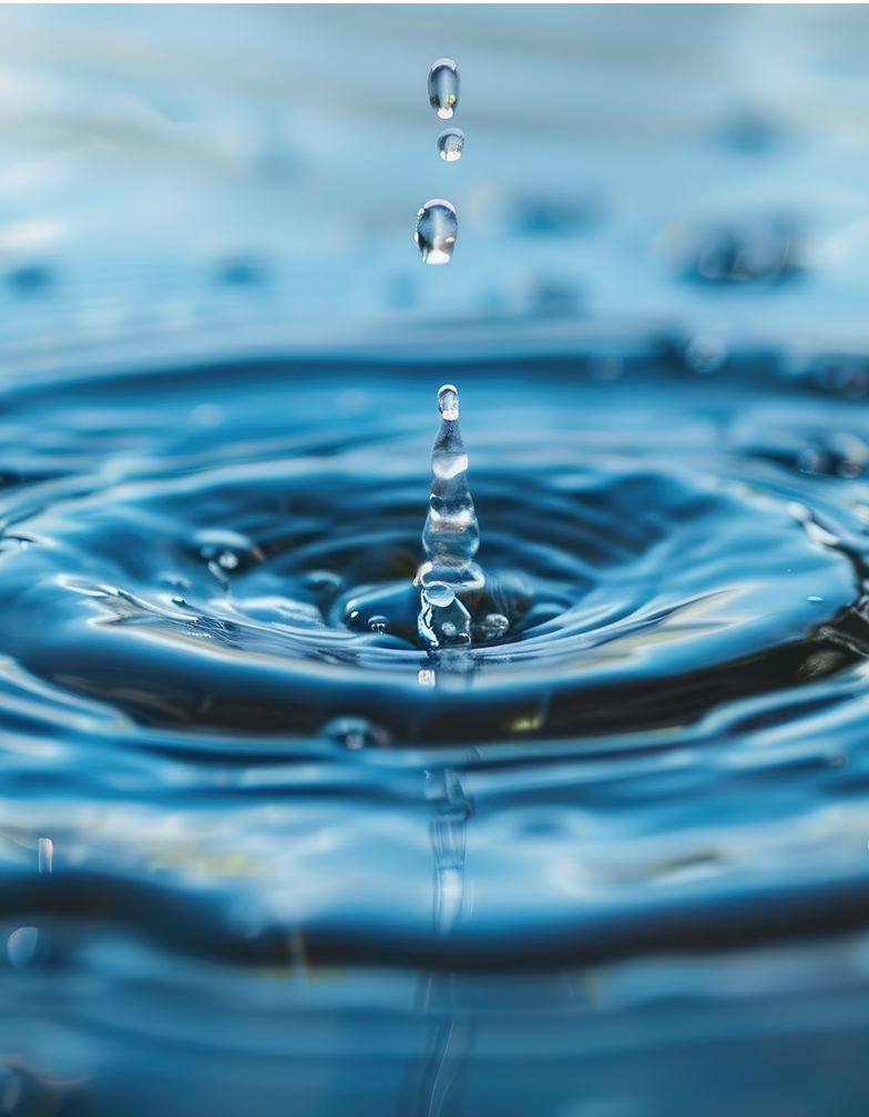 Ein fallender Wassertropfen erzeugt konzentrische Wellen auf einer ruhigen Wasseroberfläche, während sich weitere Tropfen darüber befinden.